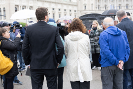 Blick von hinten auf die Kooperationspartner:innen bei einer Pressekonferenz am Heldenplatz, während Medienvertreter:innen die Situation dokumentieren © MKÖ/Alissar Najjar