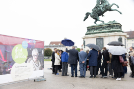 Blick auf eine Gruppe von Menschen mit Regenschirmen bei einer Pressekonferenz vor dem Erzherzog-Karl-Reiterdenkmal am Heldenplatz, flankiert von den Wänden der Gedenkausstellung am Heldenplatz © MKÖ/Alissar Najjar 