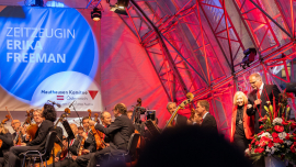 Wiener Symphoniker, Dr. Erika Freeman wird von Willi Mernyi auf die Bühne begleitet beim Fest der Freude 2022 © MKÖ/Sebastian Philipp