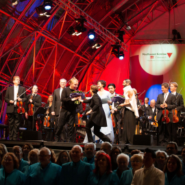 Dirigentin Eva Ollikainen überreicht Violinisten Pekka Kuusisto einen Blumenstrauß auf der Bühne beim Fest der Freude 2019 © MKÖ/Alissar 